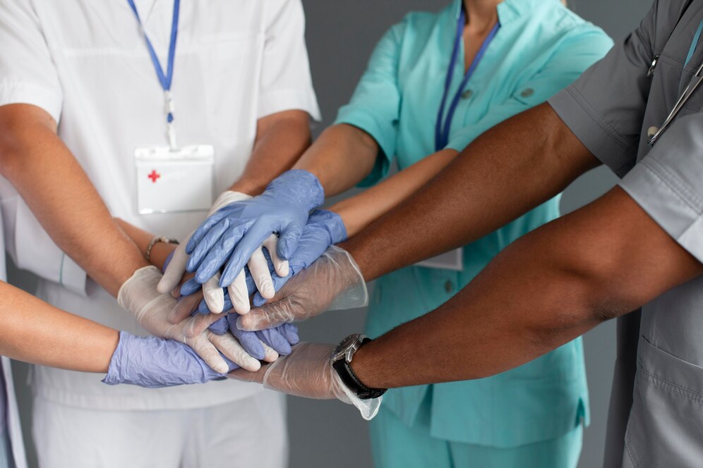 Close up nas mãos unidas de uma equipe de profissionais de saúde